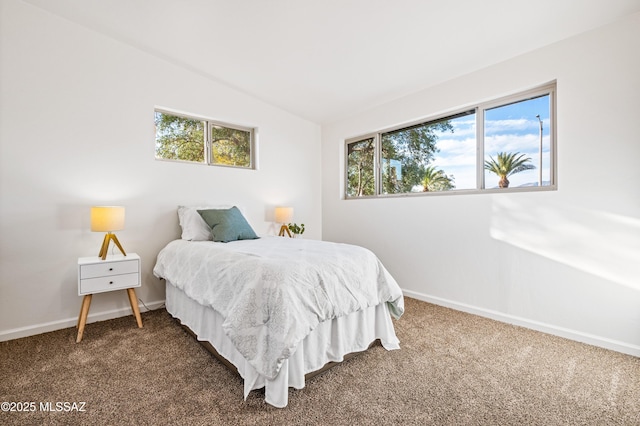 carpeted bedroom with vaulted ceiling and baseboards