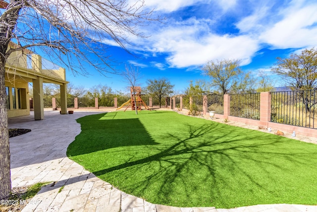 view of yard with playground community, a patio area, and a fenced backyard