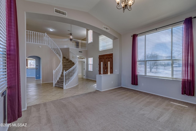 entrance foyer featuring stairway, light colored carpet, visible vents, and light tile patterned floors