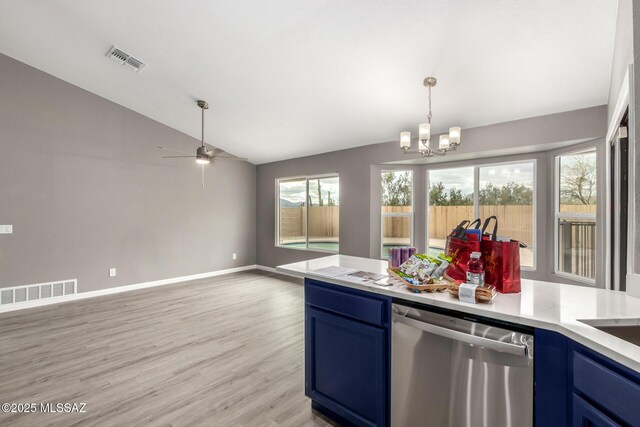 kitchen featuring stainless steel dishwasher, lofted ceiling, blue cabinets, and visible vents