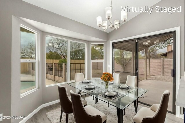 sunroom / solarium featuring a notable chandelier and vaulted ceiling