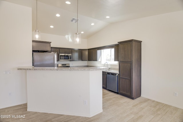 kitchen with appliances with stainless steel finishes, dark brown cabinets, light stone countertops, decorative light fixtures, and sink