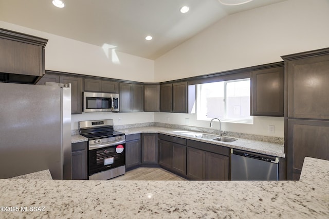 kitchen with sink, stainless steel appliances, and light stone counters