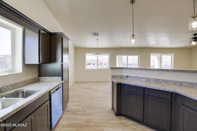 kitchen with pendant lighting, light stone countertops, and stainless steel dishwasher