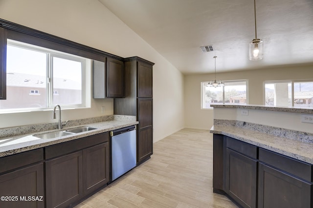 kitchen with vaulted ceiling, sink, light stone counters, decorative light fixtures, and stainless steel dishwasher