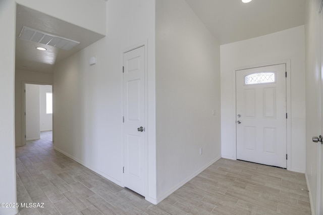 entrance foyer with light wood-type flooring and vaulted ceiling