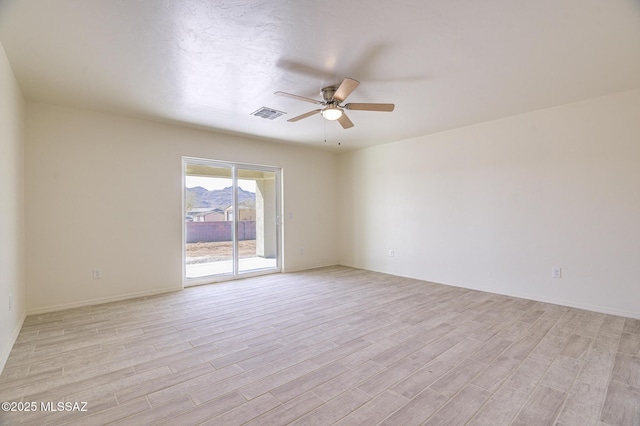 spare room featuring ceiling fan and light hardwood / wood-style flooring