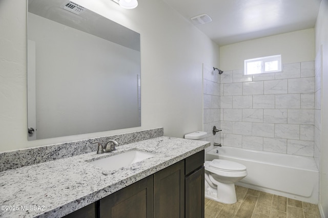 full bathroom with toilet, vanity, and tiled shower / bath combo