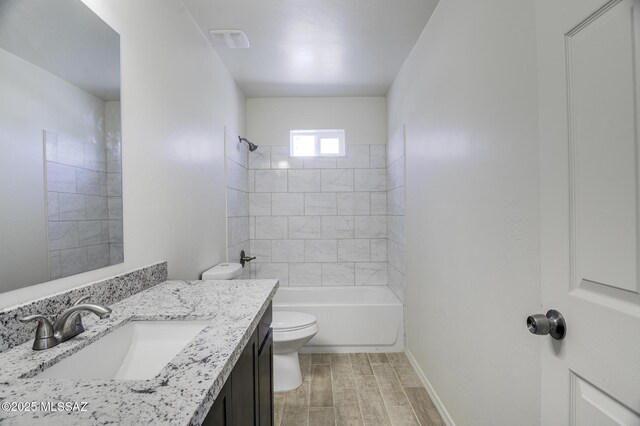 full bathroom featuring tiled shower / bath combo, vanity, and toilet