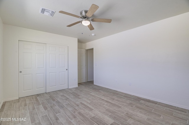 unfurnished bedroom featuring light hardwood / wood-style flooring, ceiling fan, and a closet