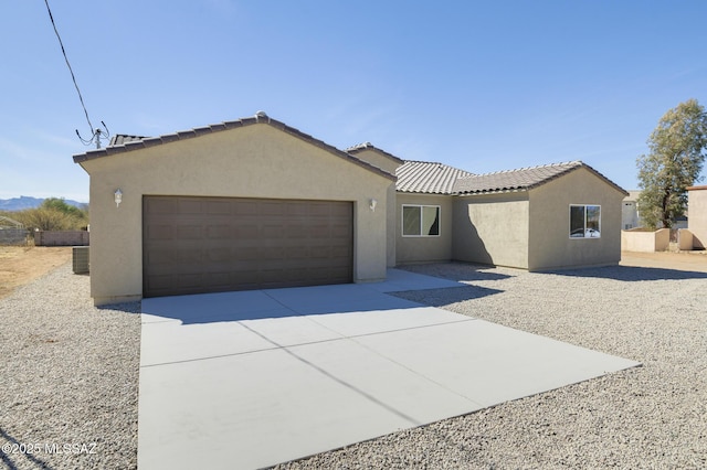 view of front of home with a garage and cooling unit