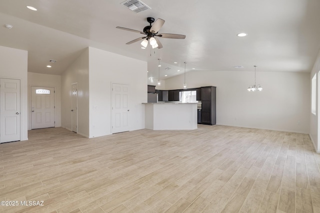 unfurnished living room with vaulted ceiling, light hardwood / wood-style floors, and ceiling fan with notable chandelier