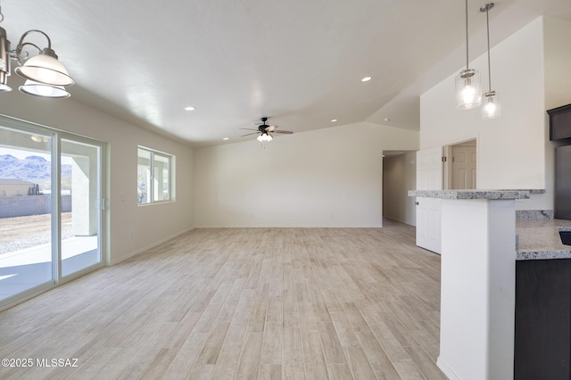 unfurnished living room featuring ceiling fan, light hardwood / wood-style flooring, and vaulted ceiling