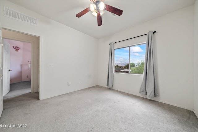 empty room featuring ceiling fan and light colored carpet