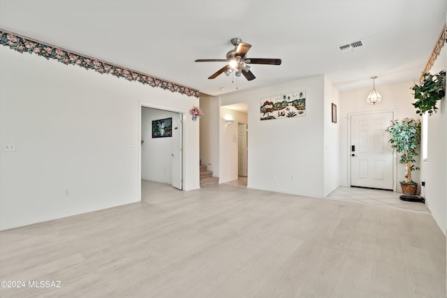 empty room with ceiling fan and light hardwood / wood-style flooring