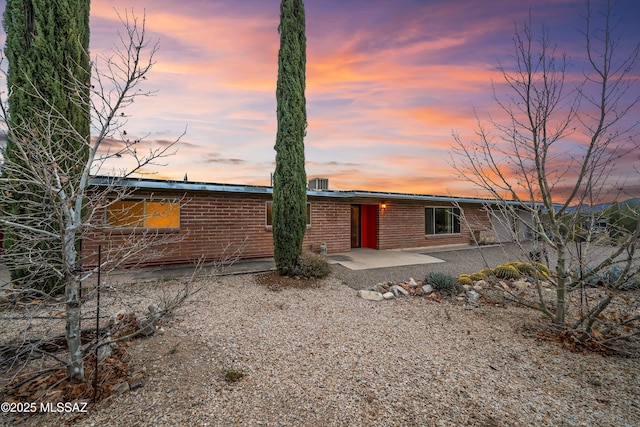 rear view of property with brick siding and a patio