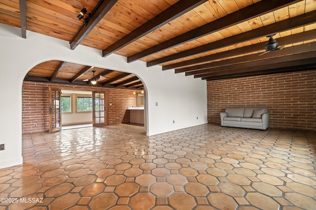 unfurnished living room with wood ceiling, brick wall, and arched walkways