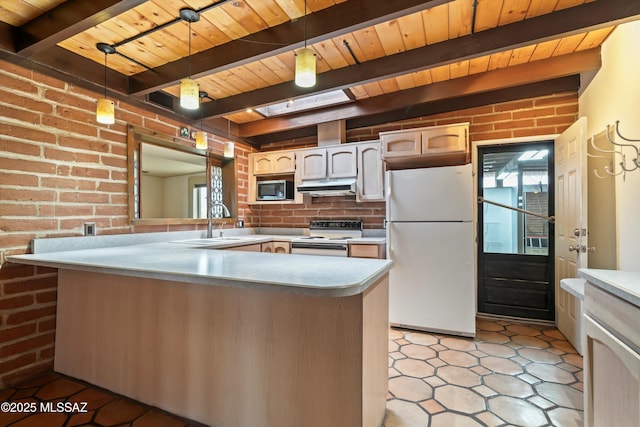 kitchen featuring white appliances, a sink, under cabinet range hood, and brick wall