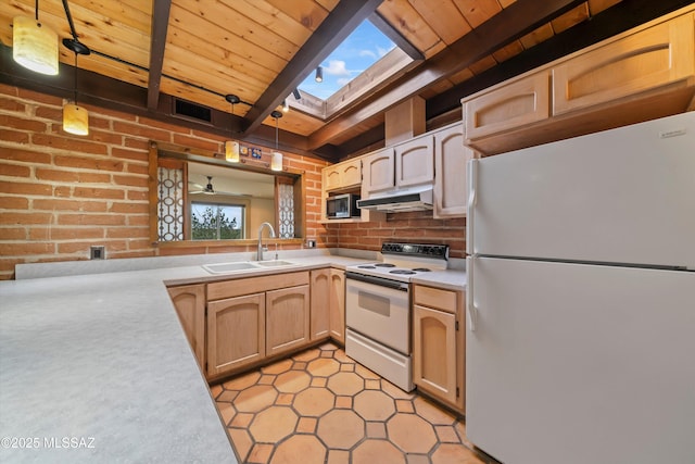 kitchen featuring a skylight, light countertops, a sink, white appliances, and under cabinet range hood