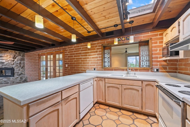 kitchen with white appliances, brick wall, a sink, and beamed ceiling