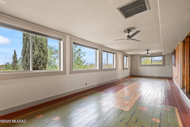 unfurnished sunroom featuring ceiling fan and visible vents