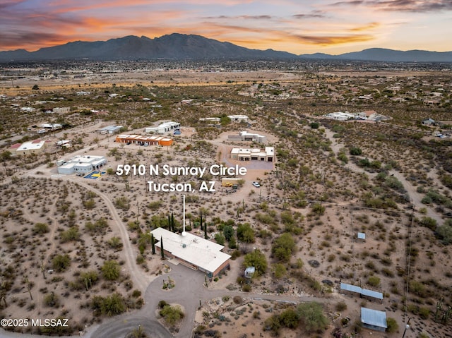 aerial view at dusk featuring view of desert and a mountain view