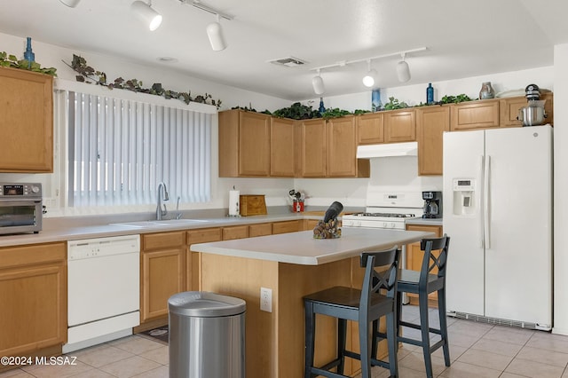 5897 E Cedarbird Dr, Tucson, AZ 85756 - kitchen featuring white appliances, a sink, under cabinet range hood, a kitchen island, and light countertops