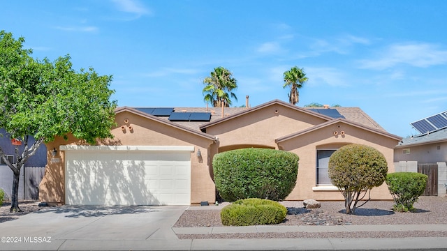 5897 E Cedarbird Dr, Tucson, AZ 85756 - view of front of home featuring driveway, stucco siding, a garage, and solar panels