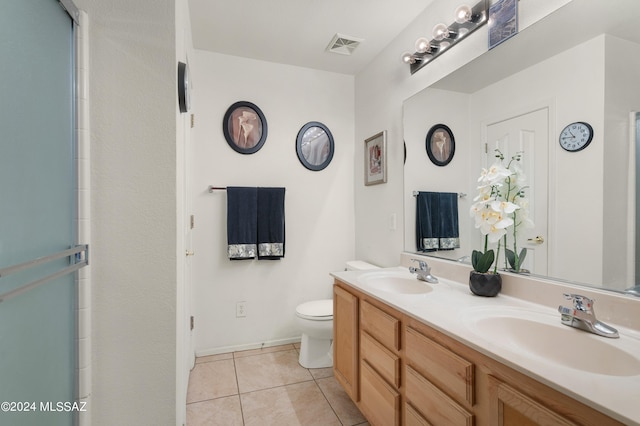 5897 E Cedarbird Dr, Tucson, AZ 85756 - bathroom featuring double vanity, toilet, tile patterned floors, a shower with shower door, and baseboards