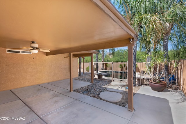 5897 E Cedarbird Dr, Tucson, AZ 85756 - fenced backyard with ceiling fan and a patio