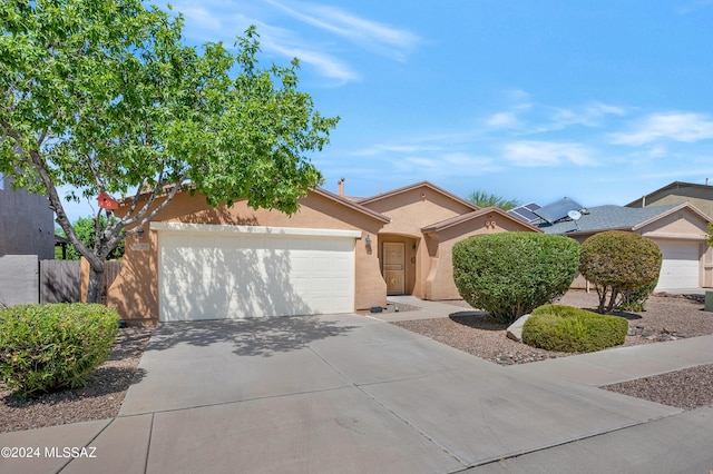 5897 E Cedarbird Dr, Tucson, AZ 85756 - view of front of house featuring a garage, driveway, and stucco siding