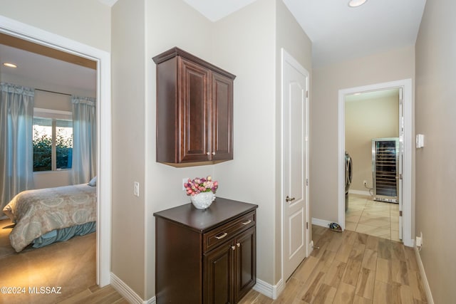 hallway with baseboards, recessed lighting, and light wood-type flooring