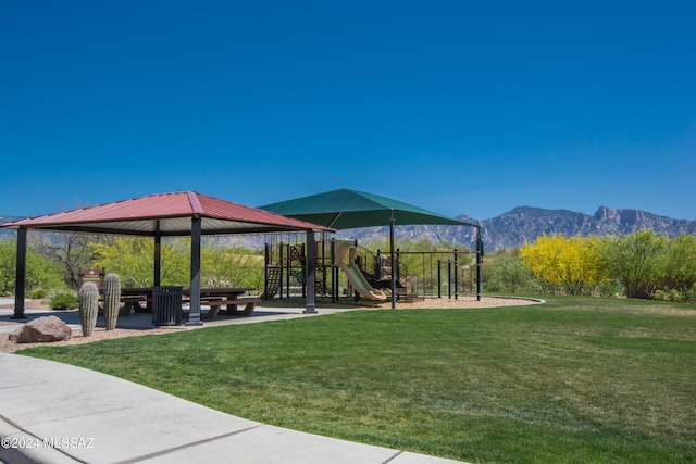 surrounding community with playground community, a mountain view, and a yard