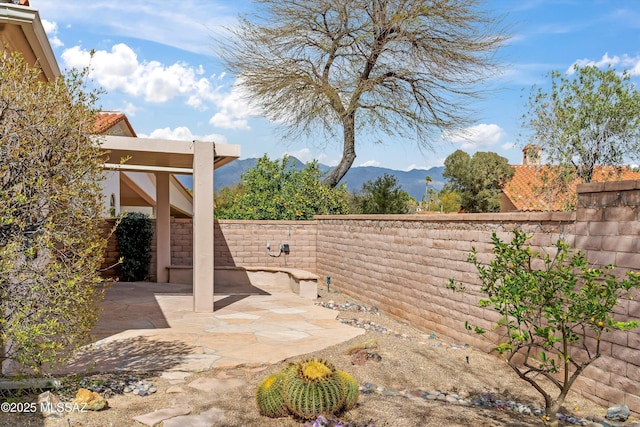 view of patio / terrace with a fenced backyard and a mountain view