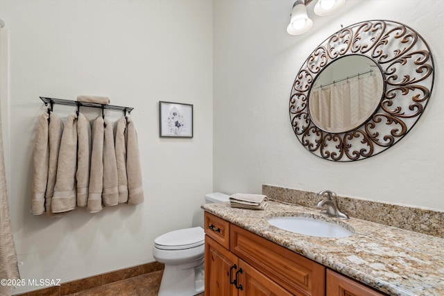 bathroom featuring tile patterned floors, vanity, toilet, and baseboards