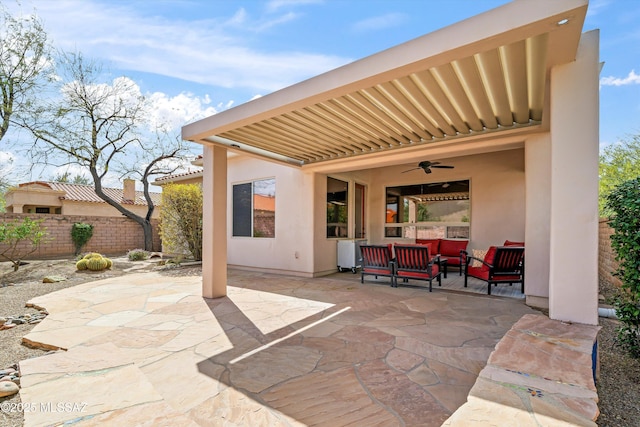 view of patio with an outdoor hangout area, fence, and a ceiling fan