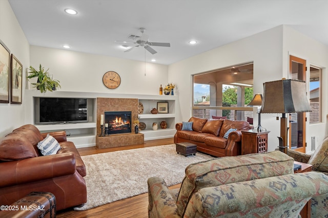 living area featuring recessed lighting, ceiling fan, wood finished floors, and a high end fireplace