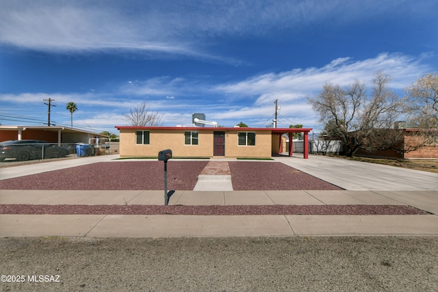 view of front of home with driveway, a carport, and stucco siding