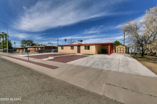 ranch-style house featuring concrete driveway, an attached carport, central AC unit, and stucco siding