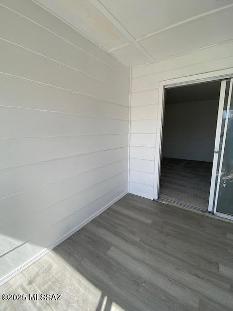 spare room with wooden walls and wood finished floors