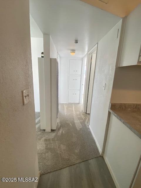 corridor featuring wood finished floors and baseboards