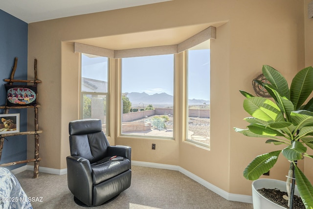 living area featuring a wealth of natural light, a mountain view, and baseboards