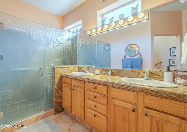 bathroom featuring double vanity, a stall shower, a sink, and tile patterned floors