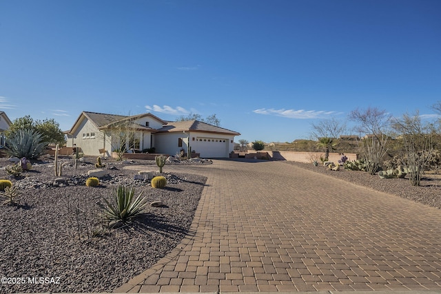 view of front of property with a garage and decorative driveway