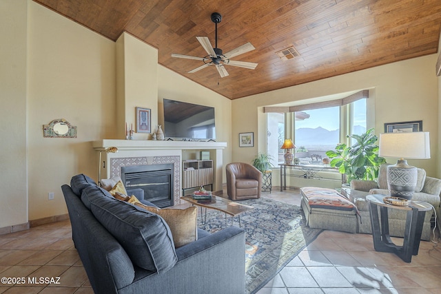 living room with light tile patterned flooring, a tiled fireplace, and wood ceiling