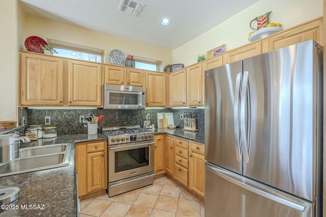 kitchen featuring light tile patterned floors, visible vents, decorative backsplash, appliances with stainless steel finishes, and a sink