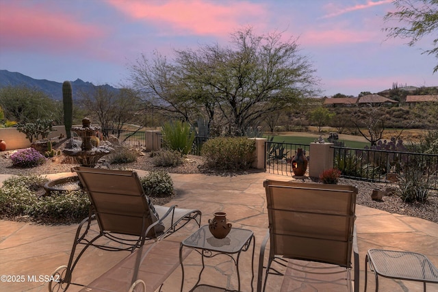 view of patio with fence and a mountain view