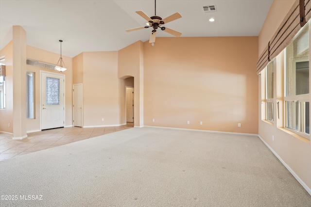 entryway with light carpet, light tile patterned floors, baseboards, visible vents, and high vaulted ceiling