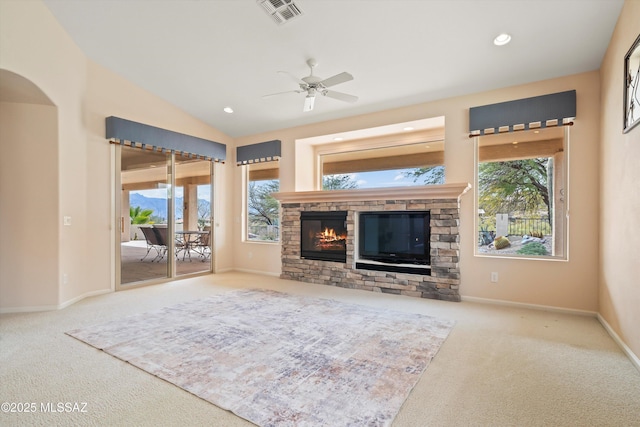 unfurnished living room with lofted ceiling, a healthy amount of sunlight, visible vents, and a fireplace