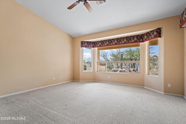 spare room featuring carpet, visible vents, vaulted ceiling, and baseboards